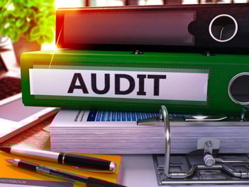 Green Office Folder with Inscription Audit on Office Desktop with Office Supplies and Modern Laptop. Audit Business Concept on Blurred Background. Audit - Toned Image